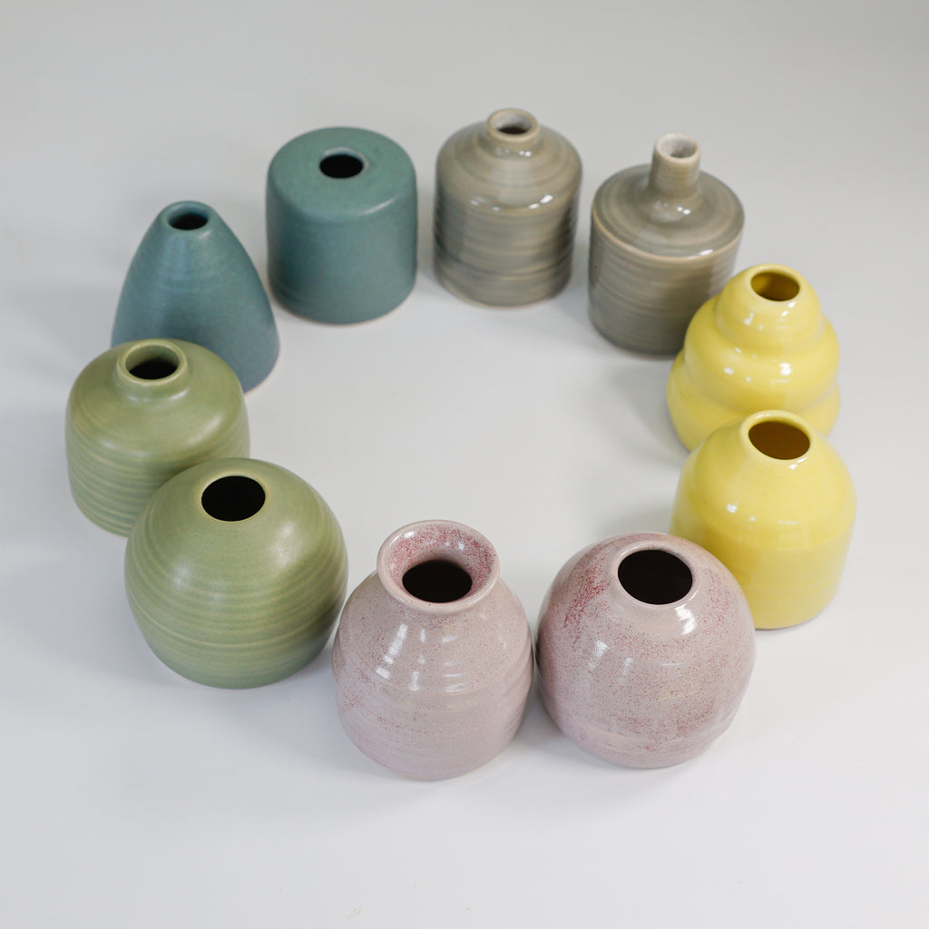 Small handmade pottery vases in a choice of colours arranged in a circle