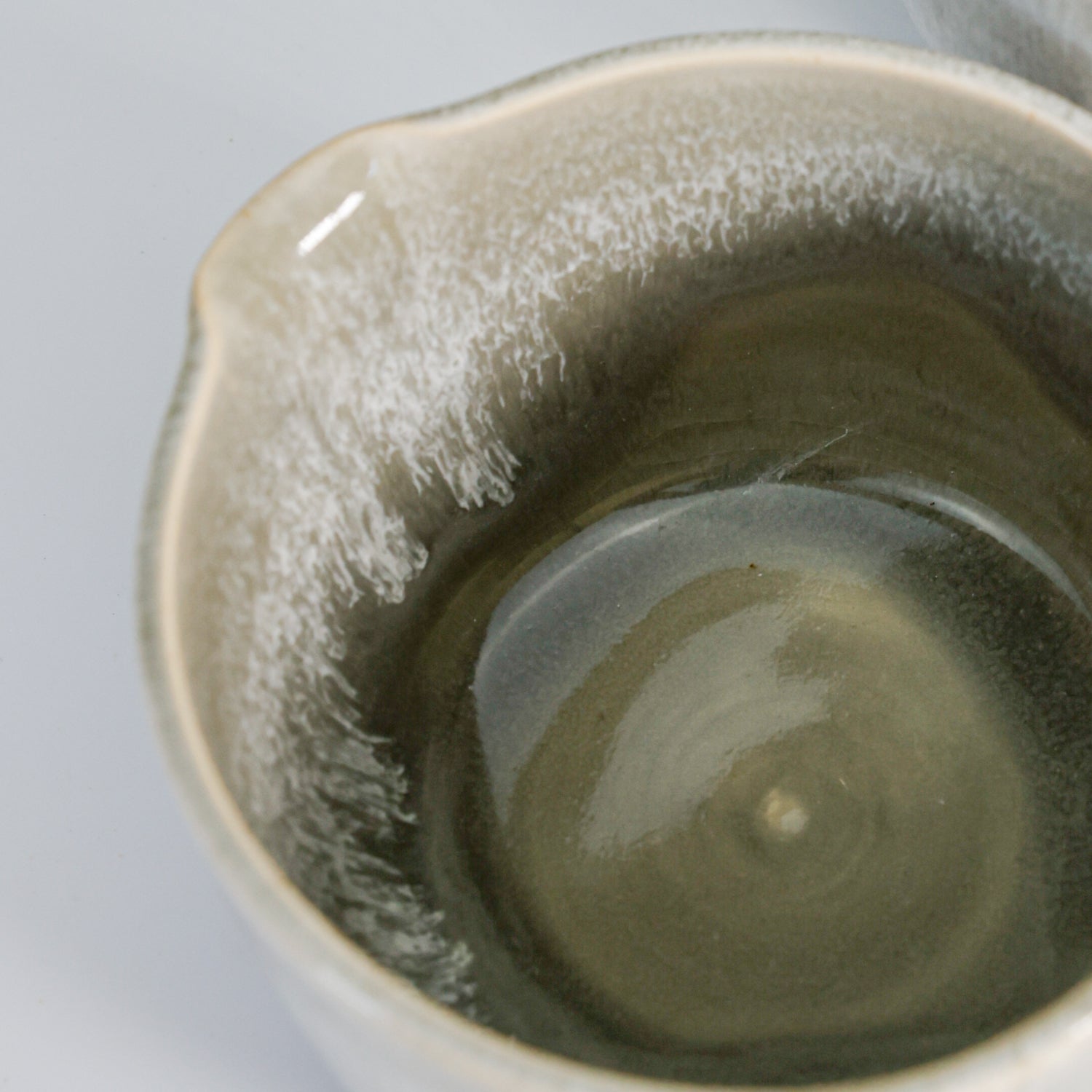 Close up of inside of grey glazed pottery gravy jug 