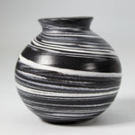 Load image into Gallery viewer, Close up of handmade ceramic mini moon jar glazed in black with white swirls
