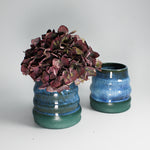 Load image into Gallery viewer, Pair of blue and green pottery mini wobble vases. One has dried flowers in.
