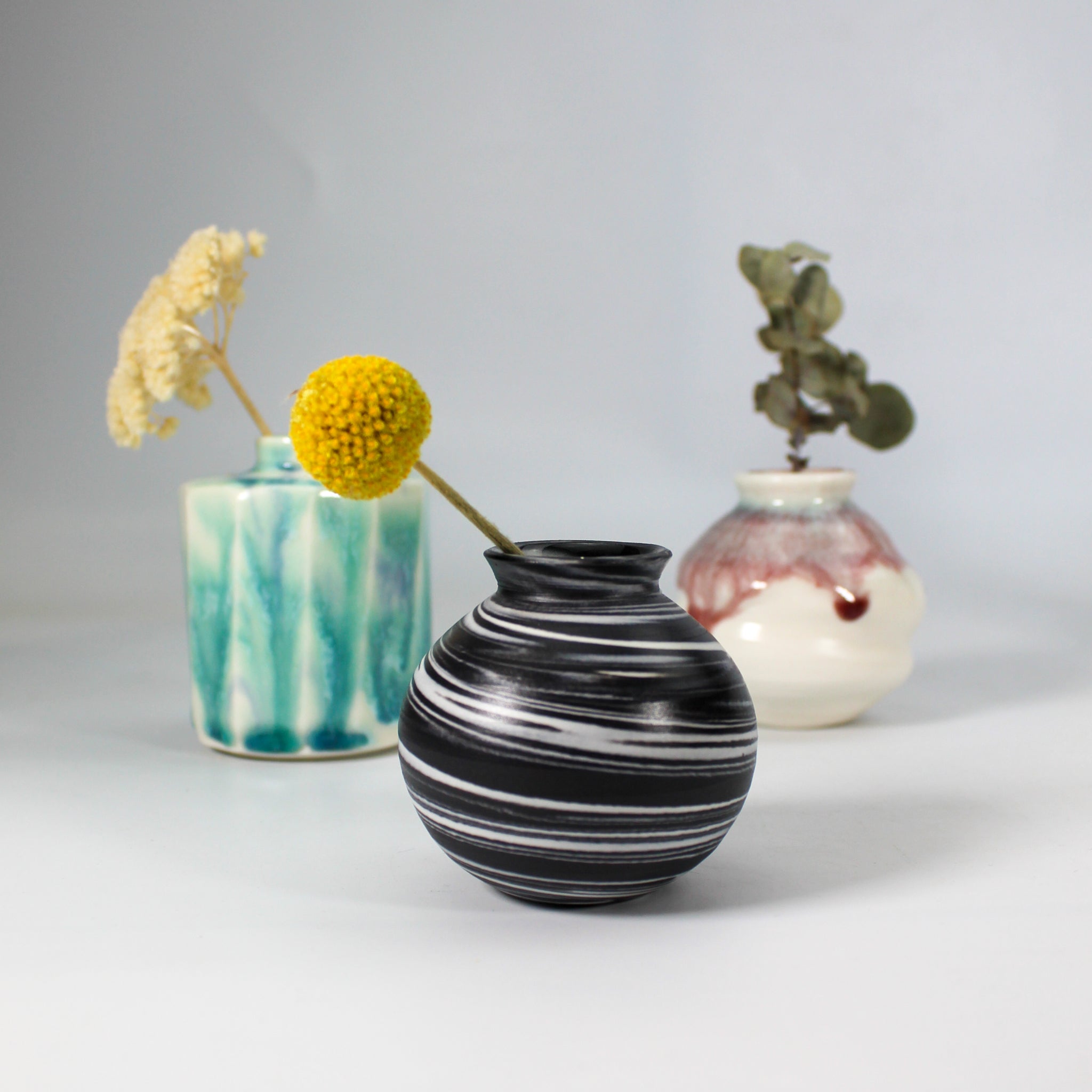 Selection of small handmade pottery vases with differing glazes