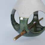 Load image into Gallery viewer, Close up of ceramic green and white bird feeder with bamboo perch 
