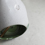 Load image into Gallery viewer, Close up of potter&#39;s mark on green and white pottery bird feeder 
