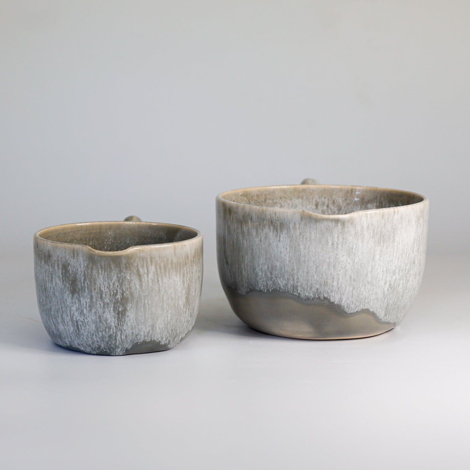 Front view of two ceramic grey glazed gravy jugs 