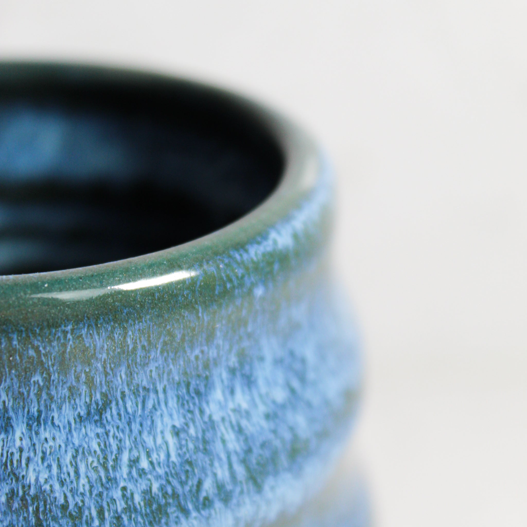 Close up of top of green and blue ceramic mini wobble vase 