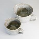 Load image into Gallery viewer, View from above of inside of two grey glazed pottery gravy jugs 
